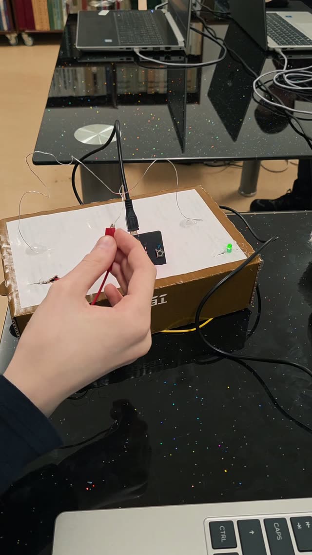 Dieťa testuje hotovú arkádovú hru Pevná ruka pripojenú na micro:bit, ktorý počíta chyby a meria čas od štartu do cieľa