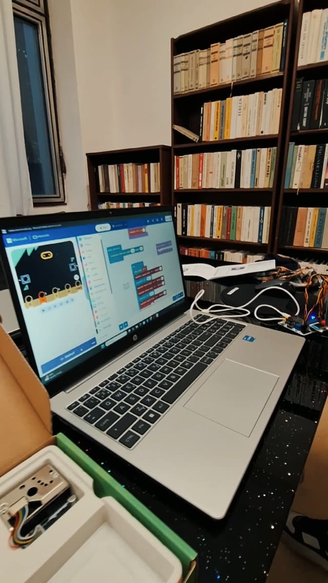 Notebook s otvoreným prostredím MakeCode a rozbalenou súpravou micro:bit, ktoré má dieťa k dispozícii na hodine